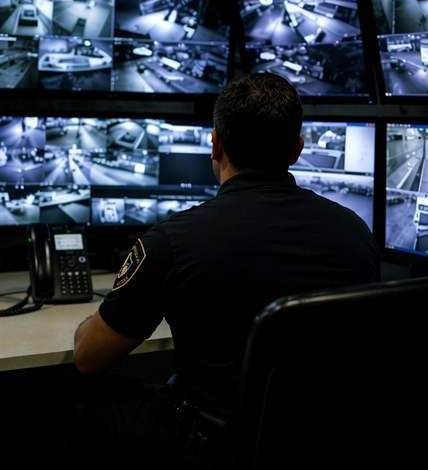 ShieldWise Security operator monitoring a wall of CCTV camera feeds in a control room
